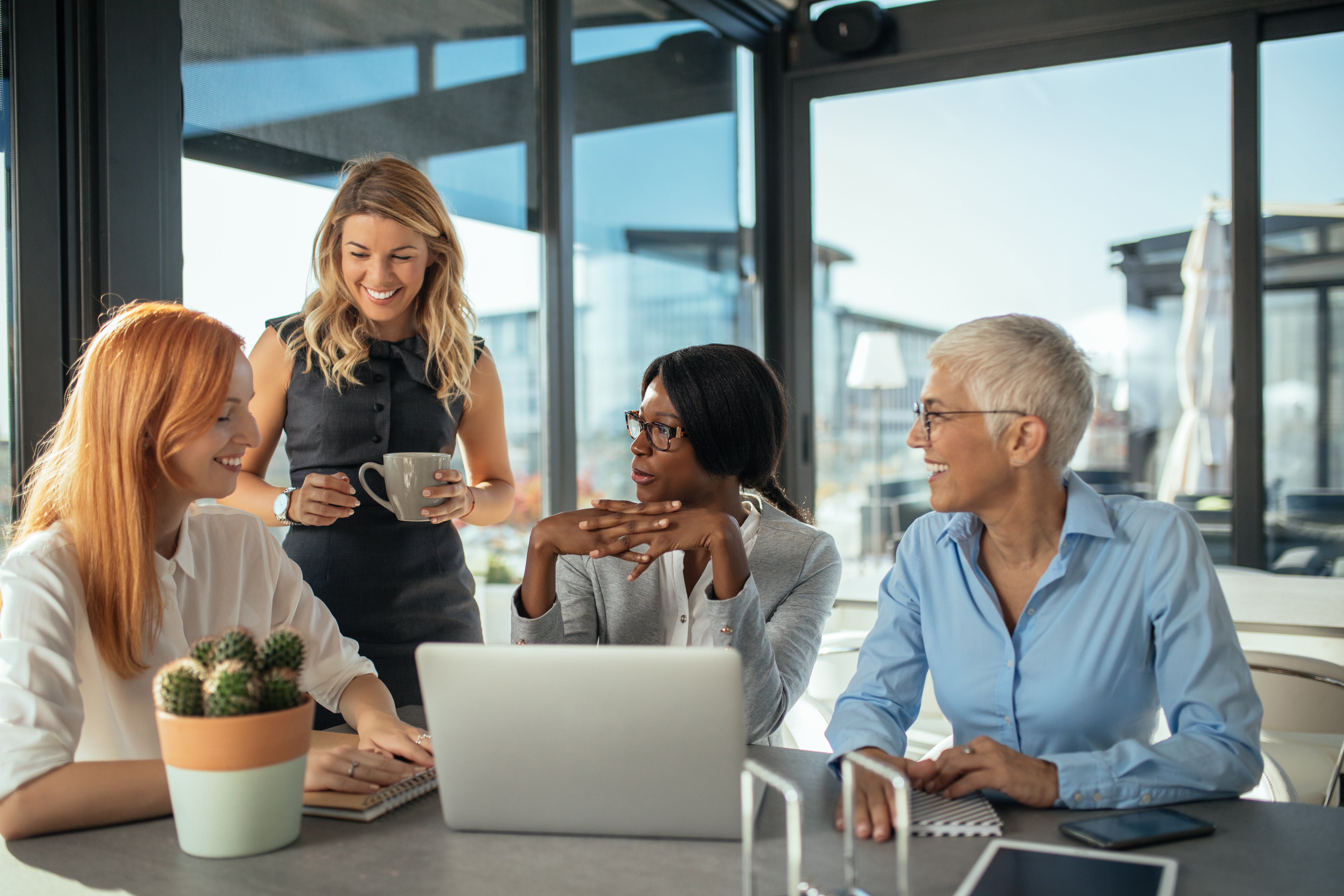 women working together at a laptop at a desk